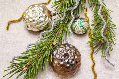 Vintage Christmas tree toys. New Year holiday concept. Evergreen pine branch, stone concrete background, close upの写真素材