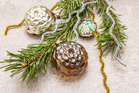 Vintage Christmas tree toys. New Year holiday concept. Evergreen pine branch, stone concrete background, close upの写真素材