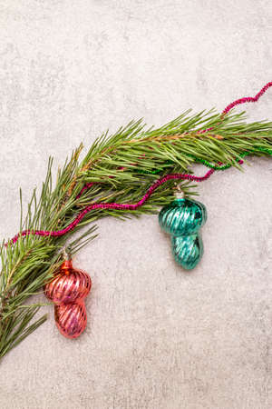 Vintage Christmas tree toys. New Year holiday concept. Evergreen pine branch, stone concrete background, copy space, top viewの写真素材