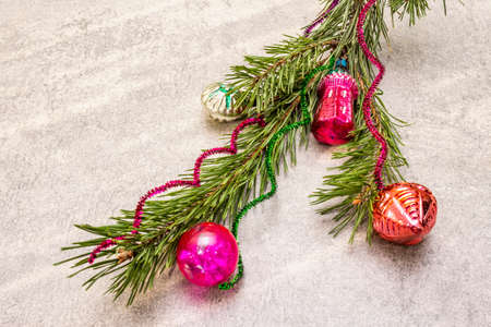 Vintage Christmas tree toys. New Year holiday concept. Evergreen pine branch, sunny rays, stone concrete background, copy spaceの写真素材