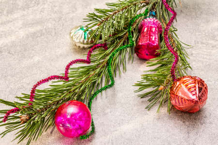 Vintage Christmas tree toys. New Year holiday concept. Evergreen pine branch, sunny rays, stone concrete background, copy space, close upの写真素材