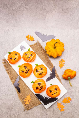 Funny Halloween Sushi Pumpkins Jack o Lantern, Sushi Monsters. Temari sushi, sushi balls. Healthy food for kids. Bats, leaves, stone concrete background, top viewの写真素材