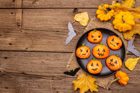Funny Halloween Sushi Pumpkins Jack o Lantern, Sushi Monsters. Temari sushi, sushi balls. Healthy food for kids. Autumn leaves, bats, old wooden boards background, copy space, top viewの写真素材