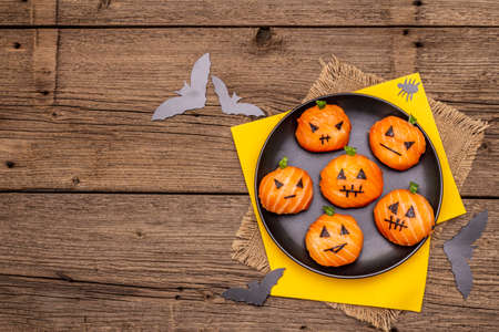 Funny Halloween Sushi Pumpkins Jack o Lantern, Sushi Monsters. Temari sushi, sushi balls. Healthy food for kids. Bats, napkins, old wooden boards background, copy space, top viewの写真素材