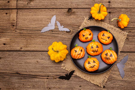 Funny Halloween Sushi Pumpkins Jack o Lantern, Sushi Monsters. Temari sushi, sushi balls. Healthy food for kids. Bats, napkin, old wooden boards background, top view, copy spaceの写真素材