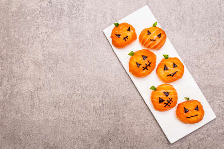 Funny Halloween Sushi Pumpkins Jack o Lantern, Sushi Monsters. Temari sushi, sushi balls. Healthy food for kids. Ceramic plate, stone concrete background, copy space, top viewの写真素材