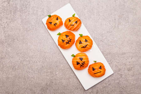 Funny Halloween Sushi Pumpkins Jack o Lantern, Sushi Monsters. Temari sushi, sushi balls. Healthy food for kids. Ceramic plate, stone concrete background, copy space, top viewの写真素材