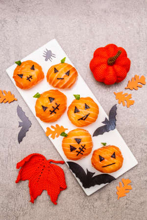 Funny Halloween Sushi Pumpkins Jack o Lantern, Sushi Monsters. Temari sushi, sushi balls. Healthy food for kids. Bats, leaves, stone concrete background, top view, close upの写真素材
