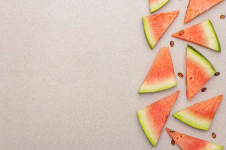 Fresh juicy slices of watermelon. Sweet summer dessert healthy eating concept. Stone concrete background, copy space, top viewの写真素材