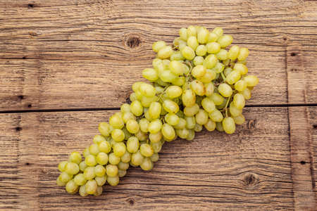 Bunch of sweet green seedless grapes variety "Kishmish". Ripe fruits autumn harvest. Healthy food concept. Old wooden boards background, copy space, top viewの写真素材