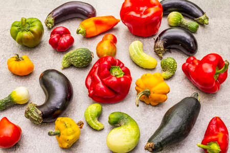 Trendy ugly organic vegetables. Assortment of fresh pepper, eggplant, cucumber, tomato, pumpkin. Cooking ugly food concept. Stone concrete backgroundの写真素材