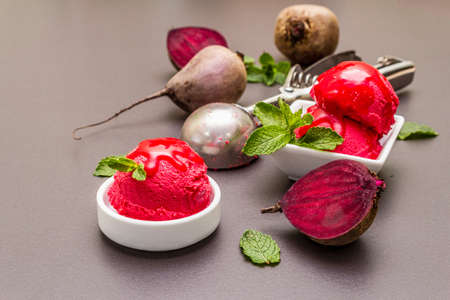 Beet ice cream, sorbet, gelato, sweet icing. Summer healthy refreshment dessert. Vegetarian (vegan) trendy food concept. With fresh vegetables and mint. Stone concrete backgroundの写真素材