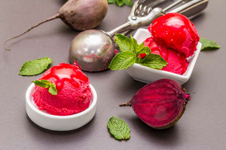 Beet ice cream, sorbet, gelato, sweet icing. Summer healthy refreshment dessert. Vegetarian (vegan) trendy food concept. With fresh vegetables and mint. Stone concrete background, close upの写真素材