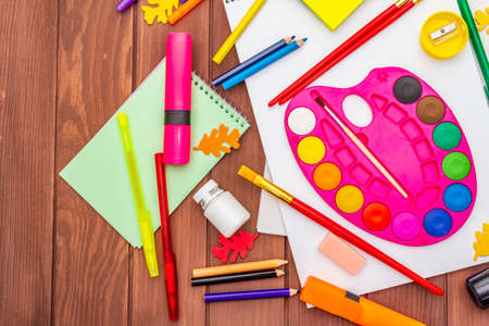Back to school concept. School education supplies on brown wooden boards background, flat , top view