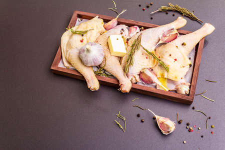 Raw chicken legs. Fresh BIO ingredient for preparation traditional food. Spice, vegetable, herbs, butter. Animal proteins and healthy fats, wooden box, stone background copy spaceの写真素材