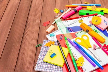 Back to school concept. School education supplies on brown wooden boards background, flat lay, copy spaceの写真素材