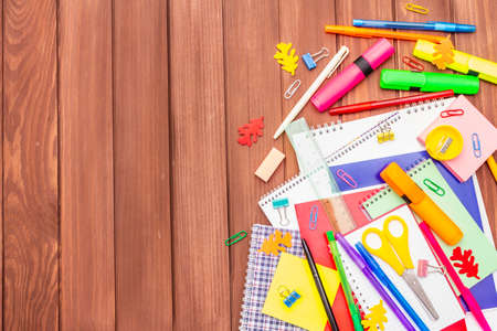 Back to school concept. School education supplies on brown wooden boards background, flat lay, copy...