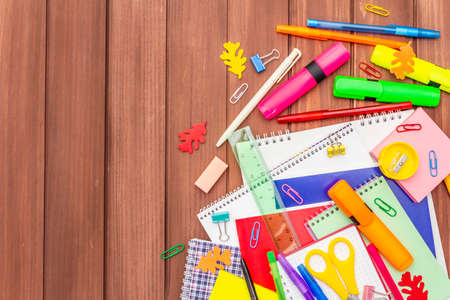 Back to school concept. School education supplies on brown wooden boards background, flat lay, copy space, top viewの写真素材
