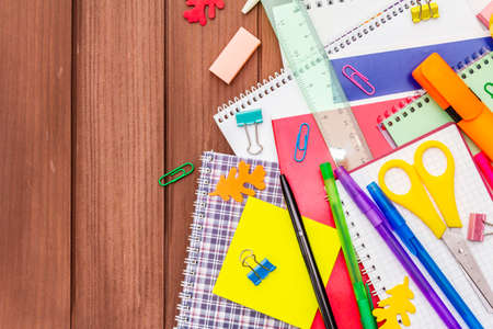 Back to school concept. School education supplies on brown wooden boards background, flat lay, copy space, top viewの写真素材