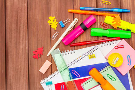 Back to school concept. School education supplies on brown wooden boards background, flat lay, copy space, top viewの写真素材