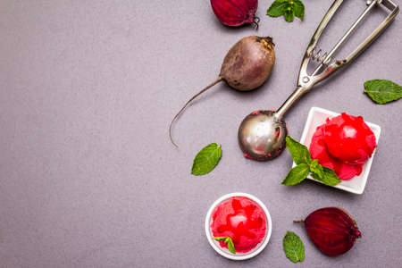 Beet ice cream, sorbet, gelato, sweet icing. Summer healthy refreshment dessert. Vegetarian (vegan) trendy food concept. With fresh vegetables and mint. Stone concrete background, copy space top viewの写真素材