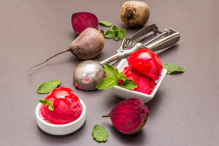 Beet ice cream, sorbet, gelato, sweet icing. Summer healthy refreshment dessert. Vegetarian (vegan) trendy food concept. With fresh vegetables and mint. Stone concrete backgroundの写真素材