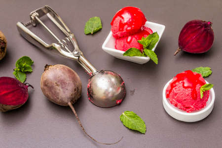 Beet ice cream, sorbet, gelato, sweet icing. Summer healthy refreshment dessert. Vegetarian (vegan) trendy food concept. With fresh vegetables and mint. Stone concrete backgroundの写真素材