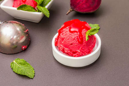 Beet ice cream, sorbet, gelato, sweet icing. Summer healthy refreshment dessert. Vegetarian (vegan) trendy food concept. With fresh vegetables and mint. Stone concrete background, close upの写真素材