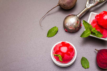 Beet ice cream, sorbet, gelato, sweet icing. Summer healthy refreshment dessert. Vegetarian (vegan) trendy food concept. With fresh vegetables and mint. Stone concrete background, copy space top viewの写真素材