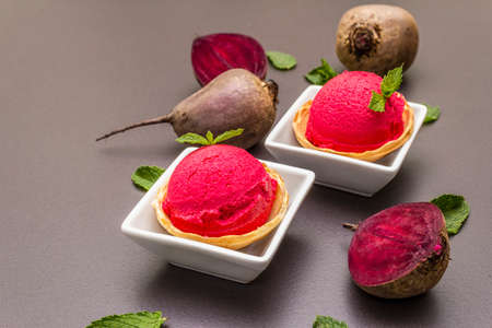 Beet ice cream, sorbet, gelato. Summer healthy refreshment dessert. Vegetarian (vegan) trendy food concept. With fresh vegetables and mint. Stone concrete background, copy space, close upの写真素材