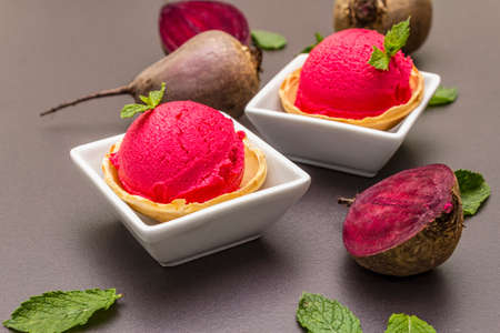 Beet ice cream, sorbet, gelato. Summer healthy refreshment dessert. Vegetarian (vegan) trendy food concept. With fresh vegetables and mint. Stone concrete background, close upの写真素材