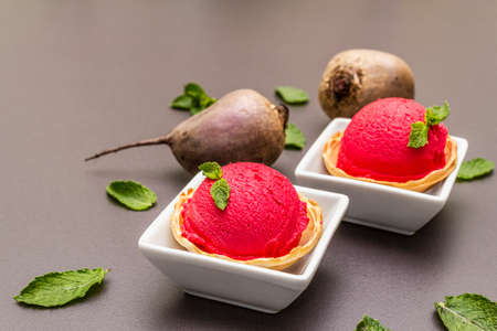 Beet ice cream, sorbet, gelato. Summer healthy refreshment dessert. Vegetarian (vegan) trendy food concept. With fresh vegetables and mint. Stone concrete background, close upの写真素材