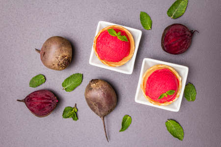 Beet ice cream, sorbet, gelato. Summer healthy refreshment dessert. Vegetarian (vegan) trendy food concept. With fresh vegetables and mint. Stone concrete background, top viewの写真素材