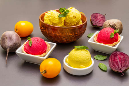 Assorted of beet and tomato ice cream, sorbet, gelato. Summer healthy refreshment dessert. Vegetarian (vegan) trendy food concept. With fresh vegetables and mint. Stone concrete backgroundの写真素材