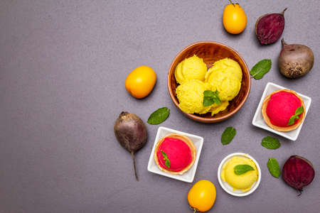 Assorted of beet and tomato ice cream, sorbet, gelato. Summer healthy refreshment dessert. Vegetarian (vegan) trendy food concept. Fresh vegetables, mint. Stone concrete background copy space top viewの写真素材