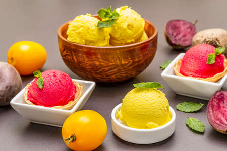 Assorted of beet and tomato ice cream, sorbet, gelato. Summer healthy refreshment dessert. Vegetarian (vegan) trendy food concept. With fresh vegetables and mint. Stone concrete background, close upの写真素材