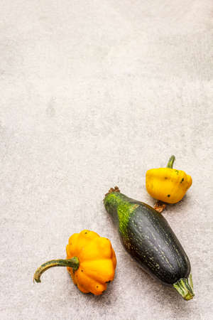 Trendy ugly organic vegetables. Fresh pumpkin and zucchini. Cooking ugly food concept. Stone concrete background, copy spaceの写真素材