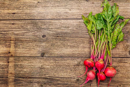 Fresh organic ripe beetroot. Autumn harvest vegetables. Preparation healthy food concept. Old vintage wooden boards background, copy space, top viewの写真素材