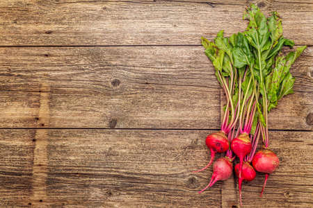 Fresh organic ripe beetroot. Autumn harvest vegetables. Preparation healthy food concept. Old vintage wooden boards background, copy space, top viewの写真素材