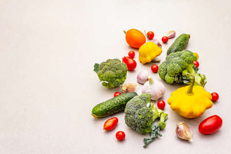Cooking food background with fresh vegetables. Autumn harvest ingredients, preparation healthy meal concept. Light stone concrete background, copy space, flat layの写真素材