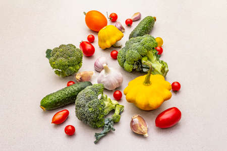 Cooking food background with fresh vegetables. Autumn harvest ingredients, preparation healthy meal concept. Light stone concrete background, close upの写真素材
