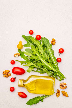 Vegan (vegetarian) healthy food concept. Fresh organic vegetables, walnuts and olive oil on stone cooking background, copy space, top viewの写真素材