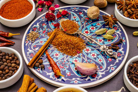 Ras el Hanout, exotic luxury spice. Ingredients for preparation oriental spice mix in ceramic bowls. An essential spice for any Moroccan dishes. Stone background close upの写真素材