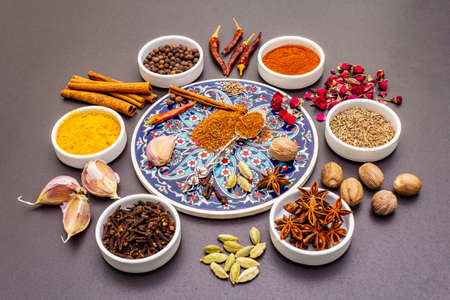 Ras el Hanout, exotic luxury spice. Ingredients for preparation oriental spice mix in ceramic bowls. An essential spice for any Moroccan dishes. Stone backgroundの写真素材