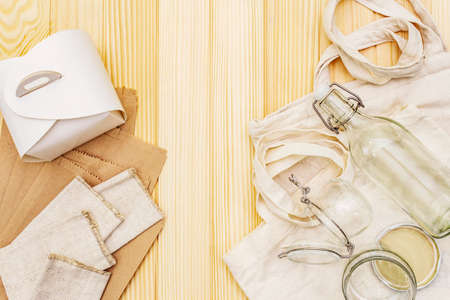 Assortment eco friendly packaging, zero waste, paper, glass and textile for free plastic shopping. Recycled materials. Bags, jars, box, bottle, packet on wooden boards background, copy space top viewの写真素材