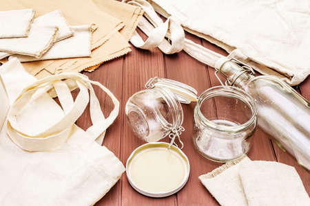 Assortment eco friendly packaging, zero waste, paper, glass and textile for free plastic shopping. Recycled materials. Bags, jars, box, bottle, packet on wooden boards background.の写真素材