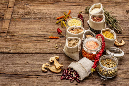 Zero waste food shopping concept. Cereals, pasta, legumes, dried mushrooms, spices. Sustainable lifestyle, old wooden boards background, copy spaceの写真素材