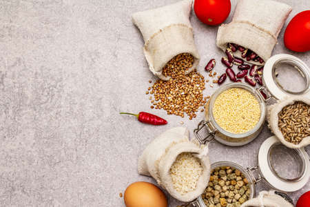 Zero waste food shopping concept. Cereals, pasta, legumes, dried mushrooms, spices, fresh vegetables. Sustainable lifestyle, stone concrete background, copy space, top viewの写真素材