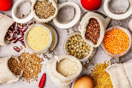 Zero waste food shopping concept. Cereals, pasta, legumes, dried mushrooms, spices, fresh vegetables. Sustainable lifestyle, stone concrete background, top view, Close upの写真素材