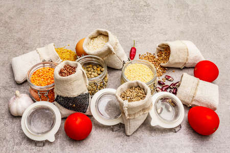 Zero waste food shopping concept. Cereals, pasta, legumes, dried mushrooms, spices, fresh vegetables. Sustainable lifestyle, stone concrete background, Close upの写真素材